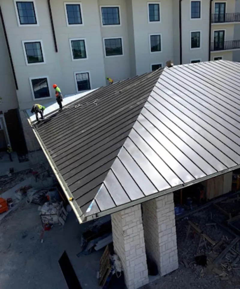 Crew installing standing seam metal roof panels on a commercial project in Waikele